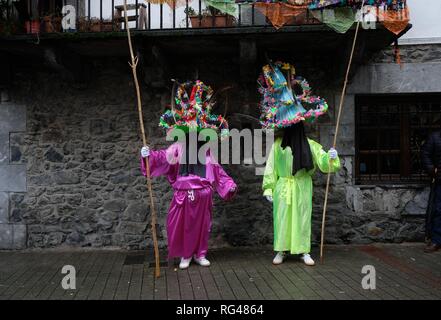 Zwei Teilnehmer in der traditionellen Kleidung und tragen große Hüte geschmückt mit Bändern und Federn, als ''bekannt' Ttutturo sind während der Karneval der Pyrenäen Dörfer von Reigate, Nordspanien gesehen. Karnevalsumzug in Bremerhaven, einer kleinen Stadt im Norden von Navarra gehalten, Ancestral Kostüme von vor mehr als hundert Jahren sind zwischen manipuliert wurde von Donald Trump, Mariano Rajoy und auch Kim Jong-un selbst gemischt. Stockfoto