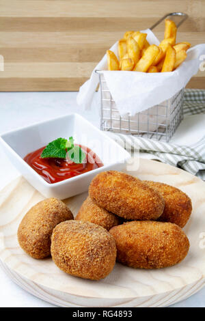 Schinken und Hähnchen Kroketten mit Chips und Tomaten Stockfoto