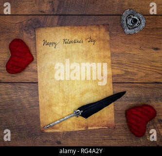 Classic Happy Valentinstag Karte Hand auf Pergament 2 rote kuscheln Herzen geschrieben reich verzierten, silbernen Feder und auf Vintage oak Ansicht von oben stehen Stockfoto
