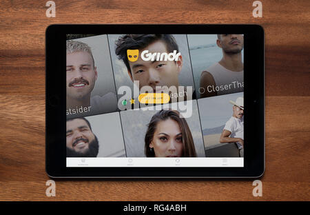 Die Website von grindr gesehen auf einem iPad Tablet, der ruht auf einem Holztisch (nur redaktionelle Nutzung). Stockfoto