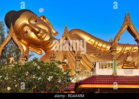 Der liegende Buddha (Buddha im Augenblick des Todes), Wat Si Sunthorn, Phuket, Thailand, kurz nach Sonnenaufgang mit dem Vollmond am Himmel über seinem Kopf Stockfoto