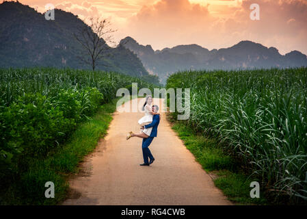 Glückliches Paar Spaß in einem Zuckerrohr Feld bei Sonnenuntergang Stockfoto