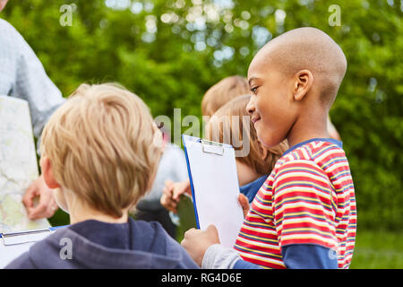 Kinder bilden zusammen ein Spiel oder eine Schatzsuche im Kindergarten Stockfoto