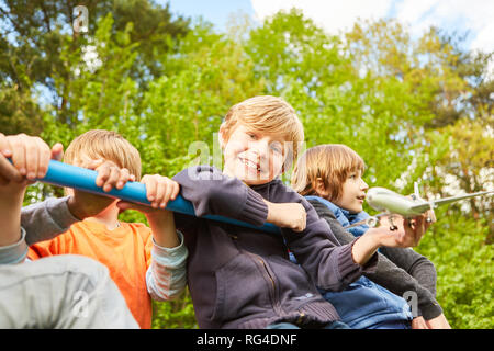 Fröhliche Gruppe von Kindern spielen auf einem Klettergerüst im Kindergarten im Sommer Stockfoto