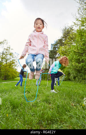 Gruppe von Kindern hat Spaß Seilspringen Wettbewerb im Park im Kindergarten Stockfoto