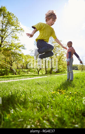 Zwei Jungen in Seilspringen zusammen im Garten im Sommer Ferien Stockfoto