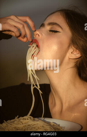 Frau essen Pasta als Vorgeschmack oder Restaurant Kritiker. Diät und gesunde Lebensmittel aus biologischem Anbau, Italien. Hunger, Appetit, Rezept. Koch Frau mit roten Lippen essen Pasta Stockfoto