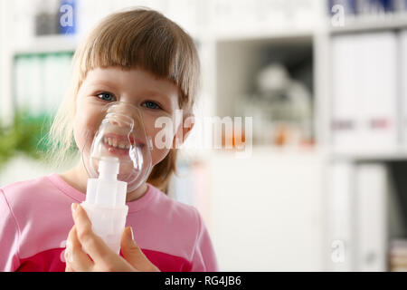 Glückliches Kind macht Inhalation zu Hause für Stockfoto