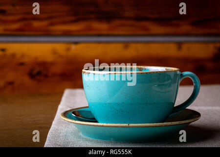 Schönen leckeren Latte Art, Blau Kaffeetasse auf Holz- Hintergrund. Stockfoto