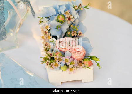 Schatulle mit Hochzeit Ringe und frische Blumen in pink-blauen Farben für Zeremonie Stockfoto