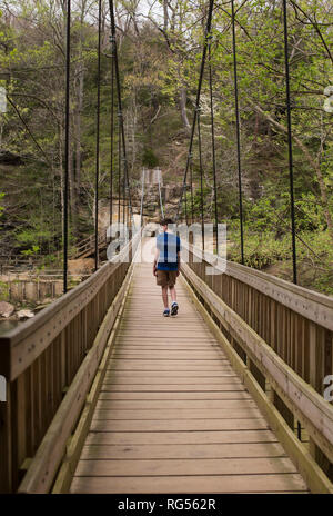 Ein Teenager Spaziergänge über die hängebrücke an die Türkei Run State Park in Parke County, Indiana, USA. Stockfoto