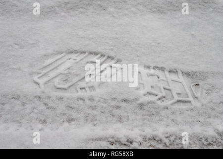 Spuren von Schuhen auf einem Schnee - gefüllte Straße. Impressum von einem Schuh im Schnee. Jahreszeit Winter. Stockfoto