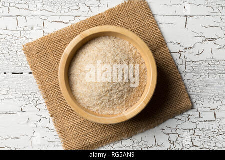 Haufen psyllium husk auch genannt Isabgol in Houten auf weißem Hintergrund. Psyllium husk auch genannt Isabgol ist Faser aus den Samen abgeleitet Stockfoto