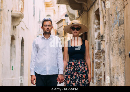 Mann hält Frau von Hand in der alten Stadt, Insel Gozo, Malta Stockfoto