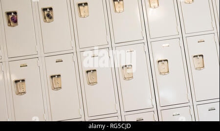 Eine Reihe von Tan Schließfächer mit zwei Vorhängeschlösser in einem pädagogischen Setting. Stockfoto