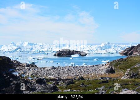 Ilulissat, Grönland, Juli | UNESCO-Weltkulturerbe | Diskobucht Kangia Icefjord | riesige Eisberge im blauen Meer an einem sonnigen Tag - globale Erwärmung Stockfoto