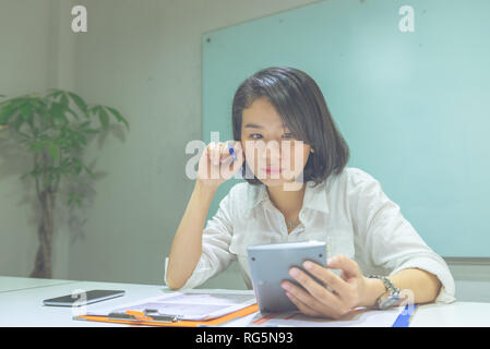 Junge asiatische Frau Arbeiten am Rechner im Büro Stockfoto