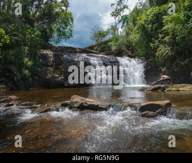 Junge Frau Yoga posieren vor Cachoeira Piu (Piu Wasserfall tun) in der Nähe der Serra do Brigadeiro Bergen, in Minas Gerais, Brasilien. Stockfoto