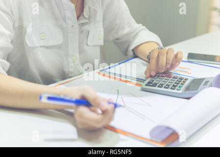 In der Nähe von Frau Hand berechnen die Verkäufe auf dem Rechner Stockfoto