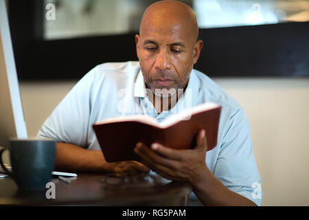 African American man beten und die Bibel lesen. Stockfoto