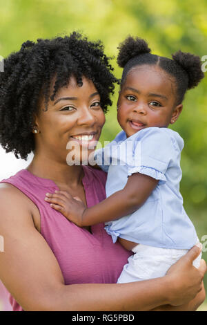 Afrikanische amerikanische Mutter lachte und umarmte ihre Tochter. Stockfoto