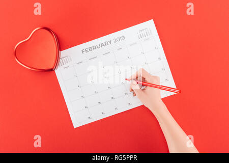 7/8-Ansicht von Frau mit Marker über Februar 2019 Kalender rot, isoliert, st Valentines Tag Konzept Stockfoto