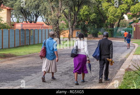 Johannesburg, Südafrika - Unbekannter schwarzer Arbeiter zu Fuß durch ein Wohngebiet suburp zur Arbeit in die Stadt Stockfoto