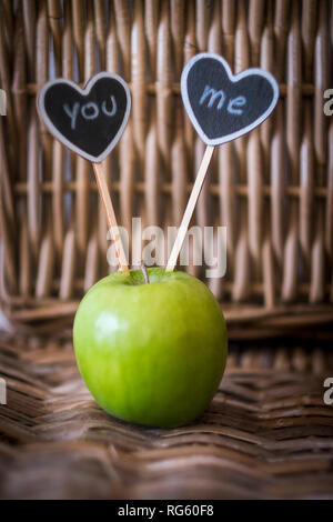 Liebe Konzept mit grünem Apfel auf dem Tisch und zwei schwarzen Herzen mit Ihnen und mir writtin - Valentinstag Perfect Image Stockfoto