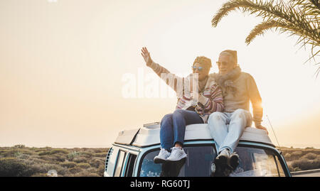 Reisen und genießen das Leben Lebensstil in Liebe für Paare in Beziehung sitzen auf dem Dach eines alten Vintage romantische Van mit Sonnenuntergang und Sonnenlicht Golde Stockfoto
