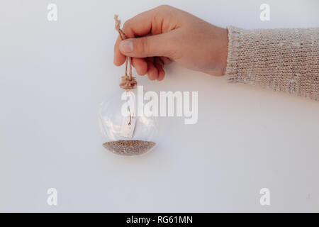 Girl's Hand mit einem Glas Christbaumkugel mit einem einen Wunsch Nachricht Stockfoto