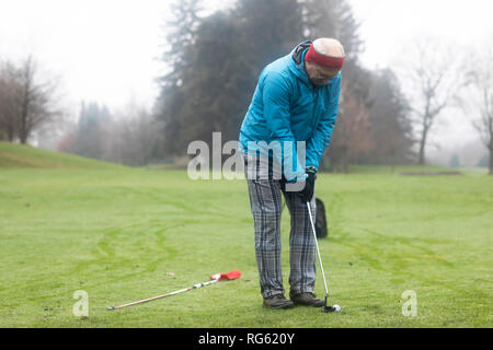 Mann spielt Golf im Winter, Deutschland Stockfoto