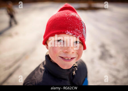 Porträt eines lächelnden Jungen um einen gefrorenen Teich, United States Stockfoto