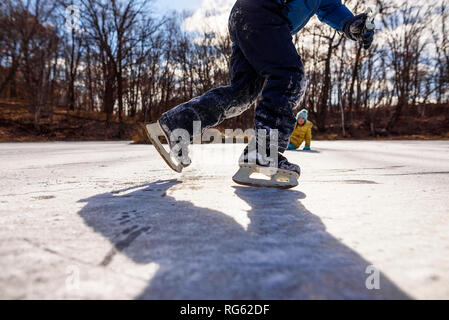 Zwei Kinder Eislaufen auf dem zugefrorenen Teich, United States Stockfoto