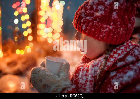 Stehendes Mädchen im Freien trinken heiße Schokolade, United States Stockfoto