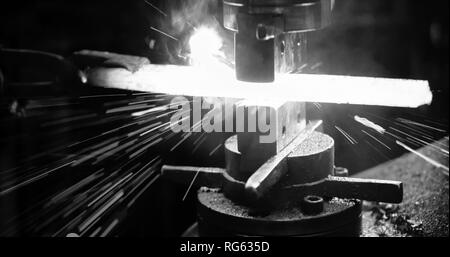 Schlosser schlägt das heiße Bügeleisen um die gewünschte Form zu geben. Stockfoto