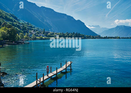 Frau posiert am Dock am Genfer See, nahe Schloss Chateau de Chillon bei Montreux, Schweiz Stockfoto