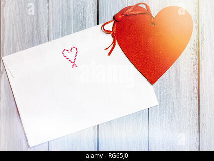 Weißen Briefumschlag und auf weißem Holz- Tabelle vorhanden, Valentines Tag Konzept Stockfoto