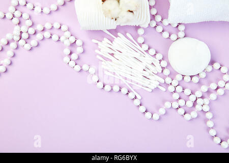 Zweig der Baumwolle, eared Sticks, Wattepads, Handtuch, Kosmetik Make-up Entferner Tampons, hygienische sanitäre Putzlappen auf lila Hintergrund der Ansicht von oben. Sp Stockfoto