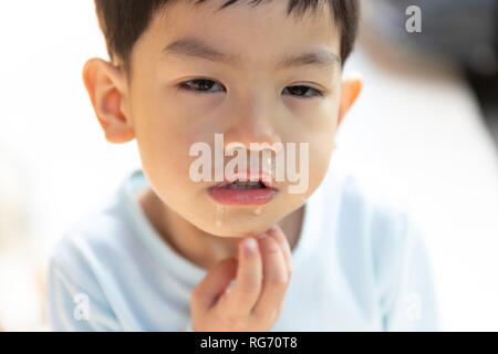 Nahaufnahme der Schleim aus der Nase, asiatische Junge hat eine laufende Nase mit klaren Rotze. Stockfoto