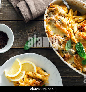 Gebackene Nudeln mit Huhn, Schinken, Mozzarella, Parmesan Ansicht von oben. Komfort Essen Stockfoto