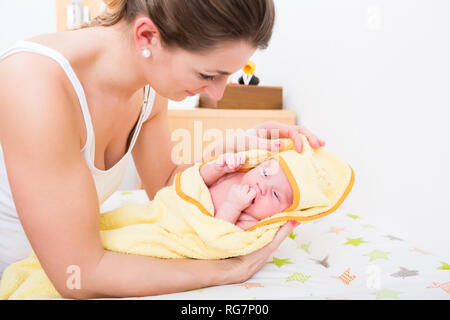 Mutter mit Baby im Tuch nach Badewanne Stockfoto