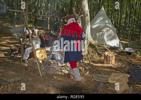 Mittelalterliches Lager im Wald Kochen im Wasserkocher Stockfoto