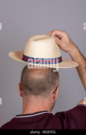 Balding Mann auf einen Strohhut für Sonnenschutz. Stockfoto