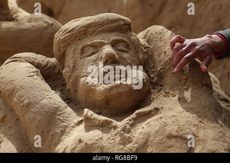 (190128) - GAZA, Jan. 28, 2019 (Xinhua) - Sand Artist Rana Ramlawi arbeitet auf ihrem Sand Skulpturen in Gaza Stadt, Jan. 24, 2019. Rana Ramlawi, ein 23 Jahre alter palästinensischer Junge Frau aus dem Gazastreifen, Erholungsorte auf Sand Kunst die Sache der Palästinenser und die israelisch-palästinensischen Konflikt zu markieren. In ihren Skulpturen aus Sand und Wasser hergestellt, viele Meldungen in Unterstützung der palästinensischen Sache vermittelt, da sie glaubt, dass Kunst ist ein wichtiger Weg, um die Rechte und die Forderung nach Freiheit zu betonen und die Beendigung der israelischen Besatzung. "Eines meiner Ziele in meinen Arbeiten ist dieses Erbe zu bewahren und zu sagen Stockfoto