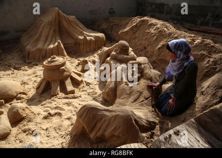 (190128) - GAZA, Jan. 28, 2019 (Xinhua) - Sand Artist Rana Ramlawi arbeitet auf ihrem Sand Skulpturen in Gaza Stadt, Jan. 24, 2019. Rana Ramlawi, ein 23 Jahre alter palästinensischer Junge Frau aus dem Gazastreifen, Erholungsorte auf Sand Kunst die Sache der Palästinenser und die israelisch-palästinensischen Konflikt zu markieren. In ihren Skulpturen aus Sand und Wasser hergestellt, viele Meldungen in Unterstützung der palästinensischen Sache vermittelt, da sie glaubt, dass Kunst ist ein wichtiger Weg, um die Rechte und die Forderung nach Freiheit zu betonen und die Beendigung der israelischen Besatzung. "Eines meiner Ziele in meinen Arbeiten ist dieses Erbe zu bewahren und zu sagen Stockfoto