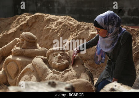 (190128) - GAZA, Jan. 28, 2019 (Xinhua) - Sand Artist Rana Ramlawi arbeitet auf ihrem Sand Skulpturen in Gaza Stadt, Jan. 24, 2019. Rana Ramlawi, ein 23 Jahre alter palästinensischer Junge Frau aus dem Gazastreifen, Erholungsorte auf Sand Kunst die Sache der Palästinenser und die israelisch-palästinensischen Konflikt zu markieren. In ihren Skulpturen aus Sand und Wasser hergestellt, viele Meldungen in Unterstützung der palästinensischen Sache vermittelt, da sie glaubt, dass Kunst ist ein wichtiger Weg, um die Rechte und die Forderung nach Freiheit zu betonen und die Beendigung der israelischen Besatzung. "Eines meiner Ziele in meinen Arbeiten ist dieses Erbe zu bewahren und zu sagen Stockfoto