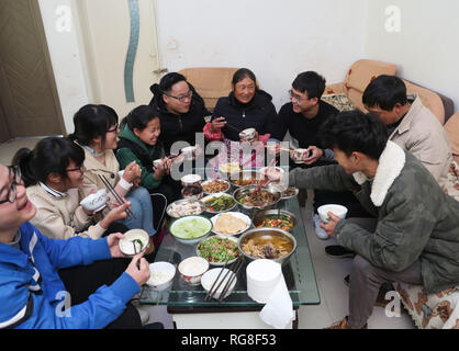 (190128) - HUIDONG, Jan. 28, 2019 (Xinhua) - Yang Mengping (3. R) Mittagessen hat mit seinen Verwandten und Freunden in seinem Haus in Qianxin Township von Huidong County im Autonomen Präfektur Liangshan Yi, der Südwesten Chinas Provinz Sichuan, Jan. 27, 2019. Yang Mengping, Student aus Shanghai-based East China Universität für Wissenschaft und Technologie, das drei Tage verbringen, Überschrift zu seinem Haus, das an Qianxin Township von Huidong County im Autonomen Präfektur Liangshan Yi, Provinz Sichuan im Südwesten Chinas befindet. Nach ca. 41 Stunden Bahnfahrt von der East China Shanghai Chengdu ich Stockfoto