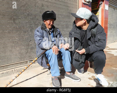 (190128) - HUIDONG, Jan. 28, 2019 (Xinhua) - Yang Mengping Chats mit seinem Großvater in Qianxin Township von Huidong County im Autonomen Präfektur Liangshan Yi, der Südwesten Chinas Provinz Sichuan, Jan. 27, 2019. Yang Mengping, Student aus Shanghai-based East China Universität für Wissenschaft und Technologie, das drei Tage verbringen, Überschrift zu seinem Haus, das an Qianxin Township von Huidong County im Autonomen Präfektur Liangshan Yi, Provinz Sichuan im Südwesten Chinas befindet. Nach ca. 41 Stunden Bahnfahrt von der East China Shanghai, Chengdu, Sichuan, Yang hat ein coac zu nehmen Stockfoto