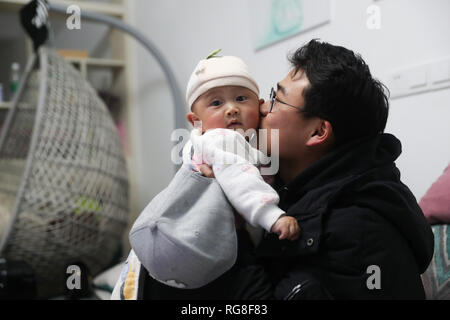 (190128) - HUIDONG, Jan. 28, 2019 (Xinhua) - Yang Mengping kisses Baby seiner Schwester in Huidong Grafschaft der Autonomen Präfektur Liangshan Yi, der Südwesten Chinas Provinz Sichuan, Jan. 26, 2019. Yang Mengping, Student aus Shanghai-based East China Universität für Wissenschaft und Technologie, das drei Tage verbringen, Überschrift zu seinem Haus, das an Qianxin Township von Huidong County im Autonomen Präfektur Liangshan Yi, Provinz Sichuan im Südwesten Chinas befindet. Nach ca. 41 Stunden Bahnfahrt von der East China Shanghai, Chengdu, Sichuan, Yang hat einen Trainer Bus in seine Heimatstadt zu nehmen. Stockfoto