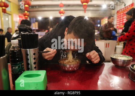 (190128) - HUIDONG, Jan. 28, 2019 (Xinhua) - Yang Mengping hat Frühstück in einem Restaurant in der Nähe des Bahnhof Chengdu Chengdu, Hauptstadt der Provinz Sichuan im Südwesten Chinas, Jan. 26, 2019. Yang Mengping, Student aus Shanghai-based East China Universität für Wissenschaft und Technologie, das drei Tage verbringen, Überschrift zu seinem Haus, das an Qianxin Township von Huidong County im Autonomen Präfektur Liangshan Yi, Provinz Sichuan im Südwesten Chinas befindet. Nach ca. 41 Stunden Bahnfahrt von der East China Shanghai, Chengdu, Sichuan, Yang hat einen Trainer Bus zu seinem homet zu nehmen Stockfoto